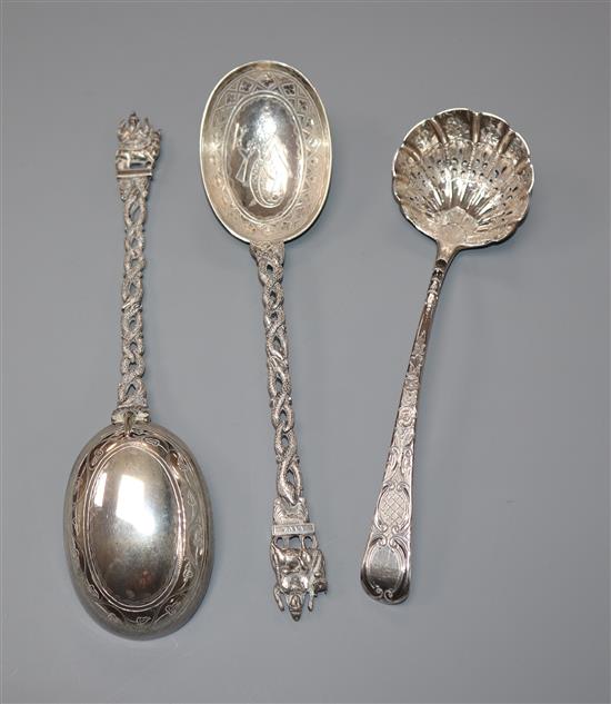 A George III silver later engraved and embossed sifter spoon and two Thai white metal preserve spoons (3)